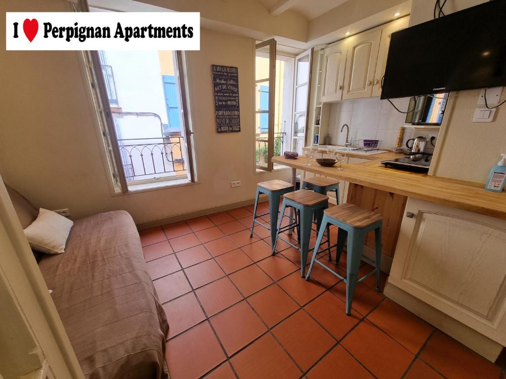 eine Küche mit einer Theke und Hockern in einem Zimmer in der Unterkunft I Love Perpignan Apartments 10 in Perpignan