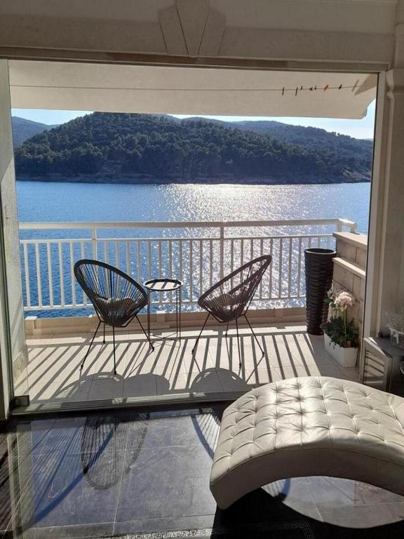 a balcony with two chairs and a view of the water at Apartment OM in Povlja