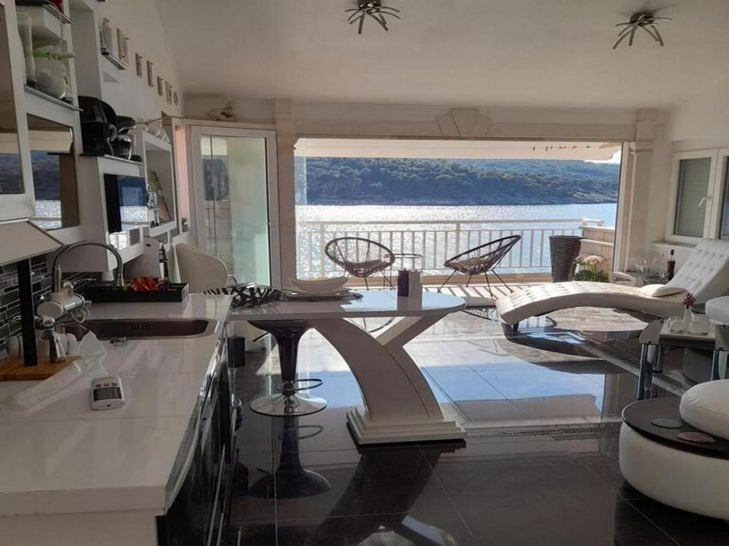 una cucina con tavolo e vista sull'oceano di Apartment OM a Povlja