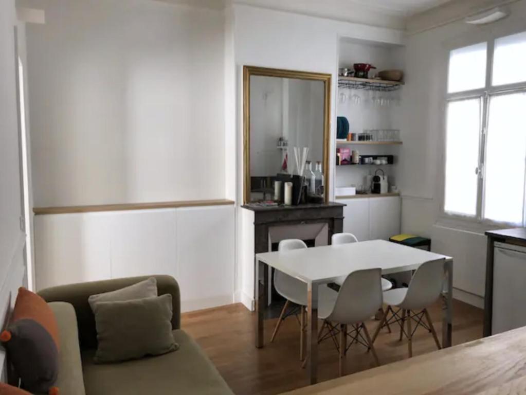 un salon avec une table et des chaises blanches dans l'établissement Paris charm suite authentique, quartier latin, 2/4 pers, à Paris