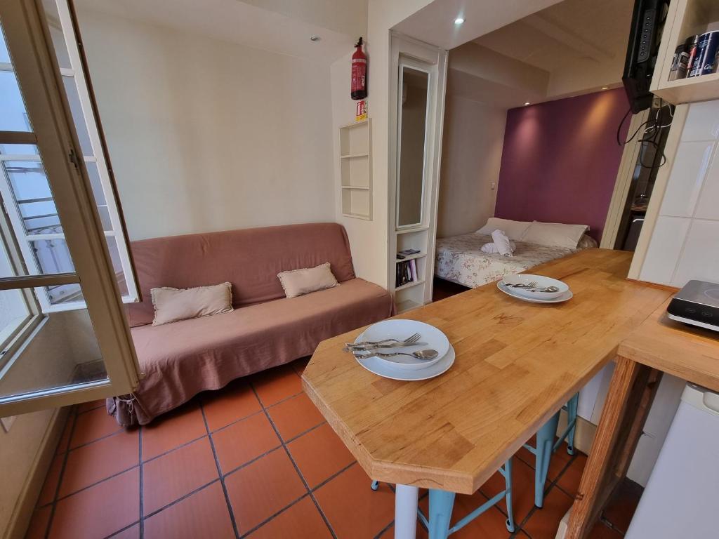 un soggiorno con un tavolo e un divano di I Love Perpignan appartment 9 a Perpignano