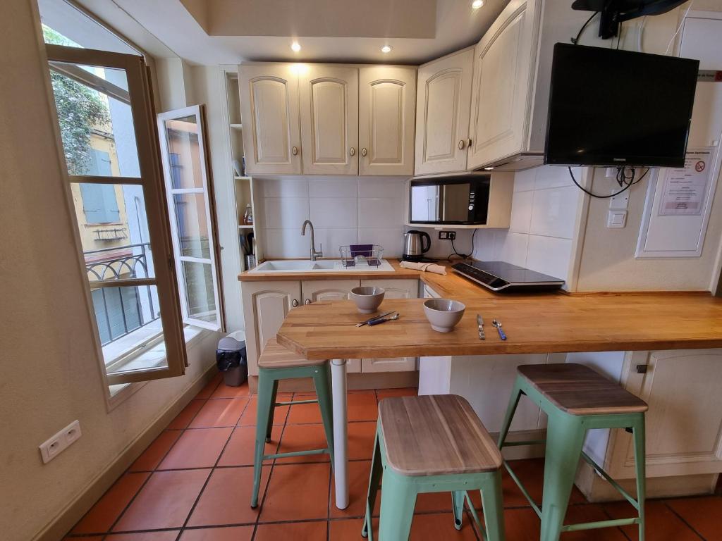 una cucina con tavolo in legno e 2 sgabelli di I Love Perpignan Apartments 8 a Perpignano