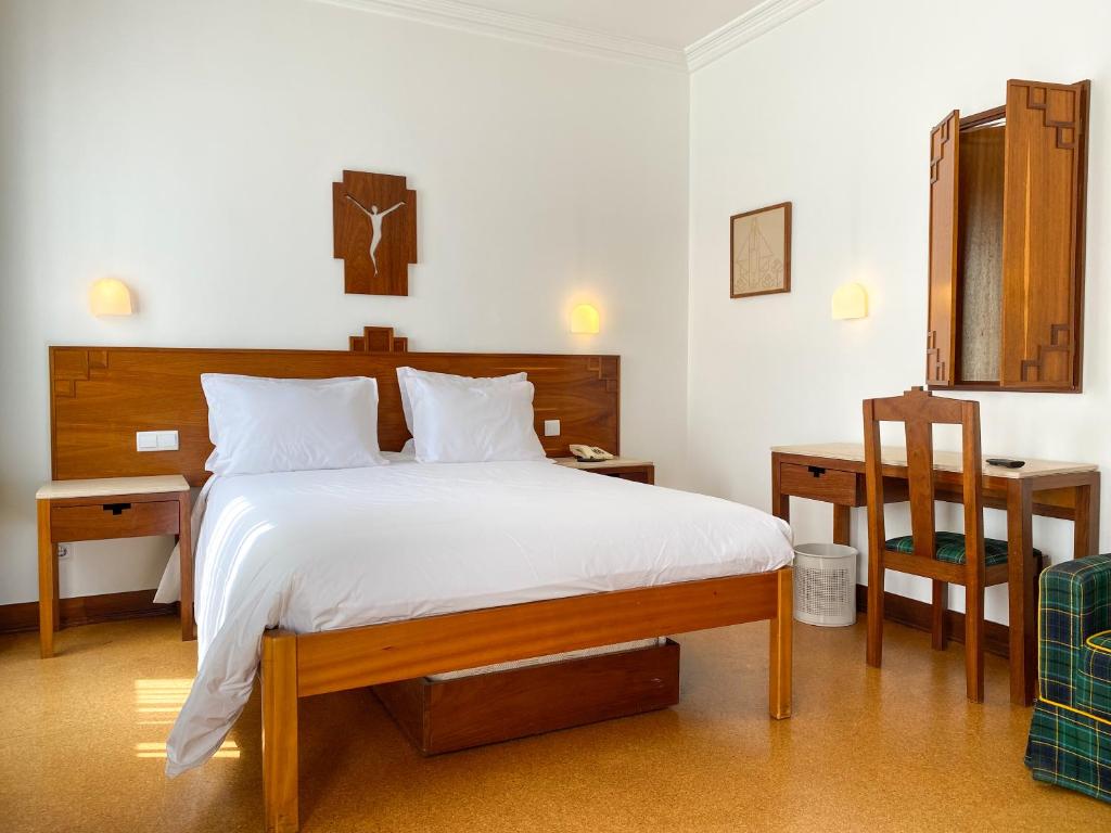 ファティマにあるFlag Hotel Fatima Casa Das Irmas Dominicanasのベッドルーム1室(ベッド1台、テーブル、椅子付)