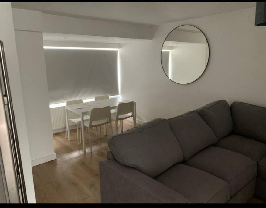 uma sala de estar com um sofá, um espelho e uma mesa em Basingstoke 1x Double bed and Sofa bed em Sherborne Saint John