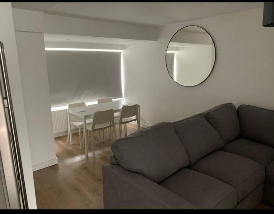 a living room with a couch and a mirror and a table at Basingstoke 1x Double bed and Sofa bed in Sherborne Saint John