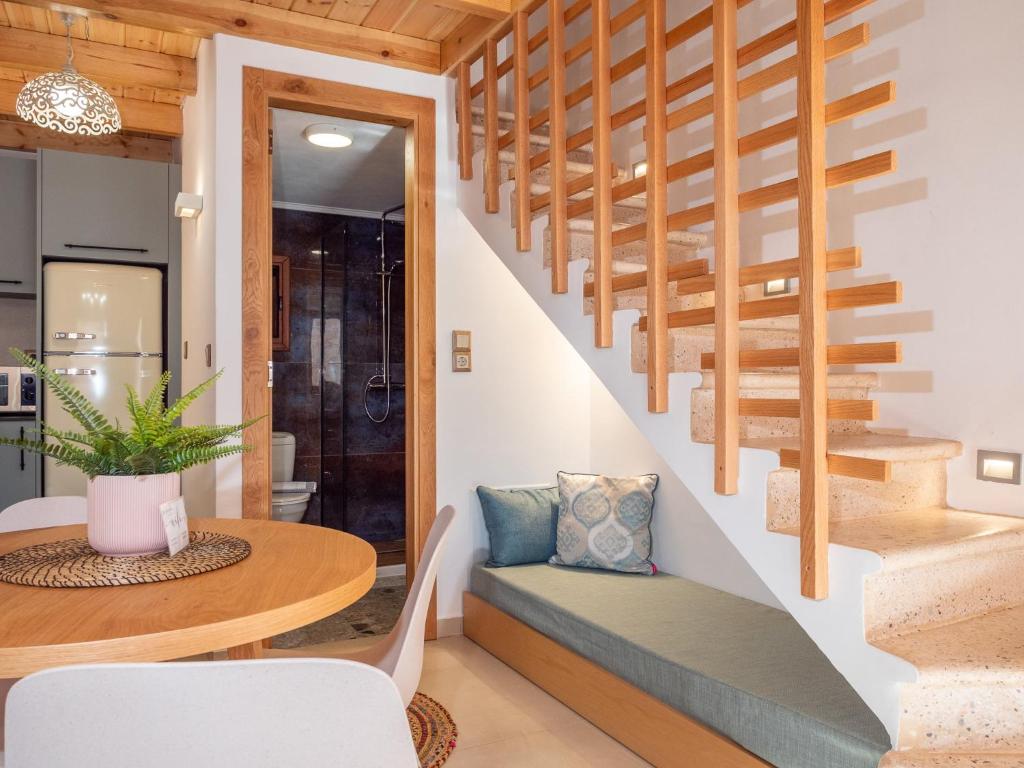 una escalera en una casa con una mesa y una silla en Captain's Memories Stylish Harbour Apartments, en Halki