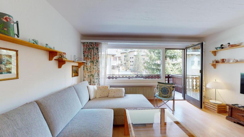 uma sala de estar com um sofá e uma janela em Guardaval 13 em Surlej