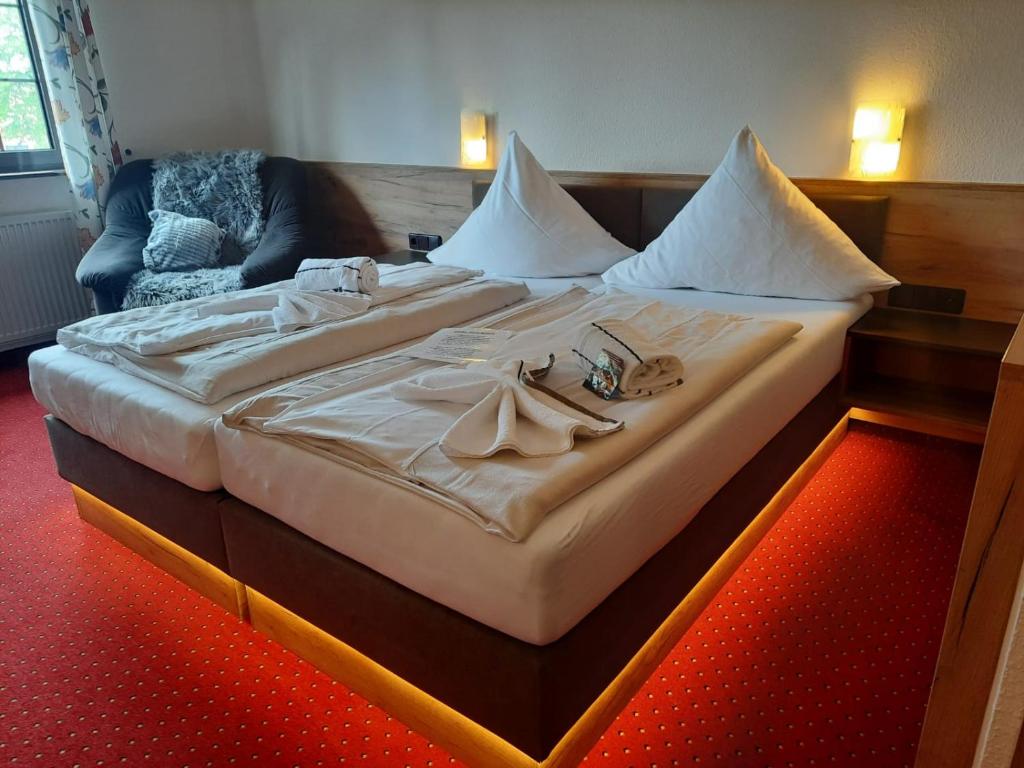 a large bed in a hotel room with shoes on it at Hotel Haus Krone in Bexbach