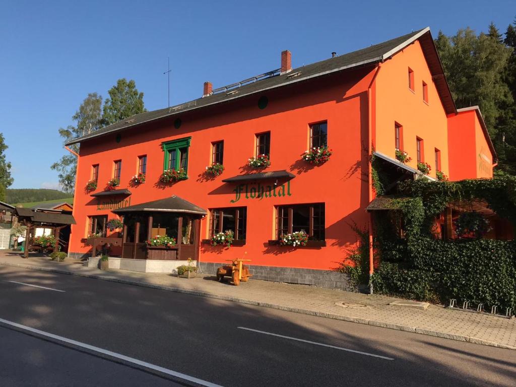 ein orangefarbenes Gebäude an der Straßenseite in der Unterkunft Landhotel Flöhatal in Heidersdorf