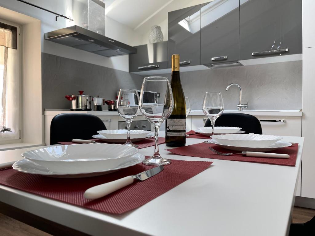 a kitchen with a table with plates and wine glasses at Appartamento Le 3 Cime in Trento