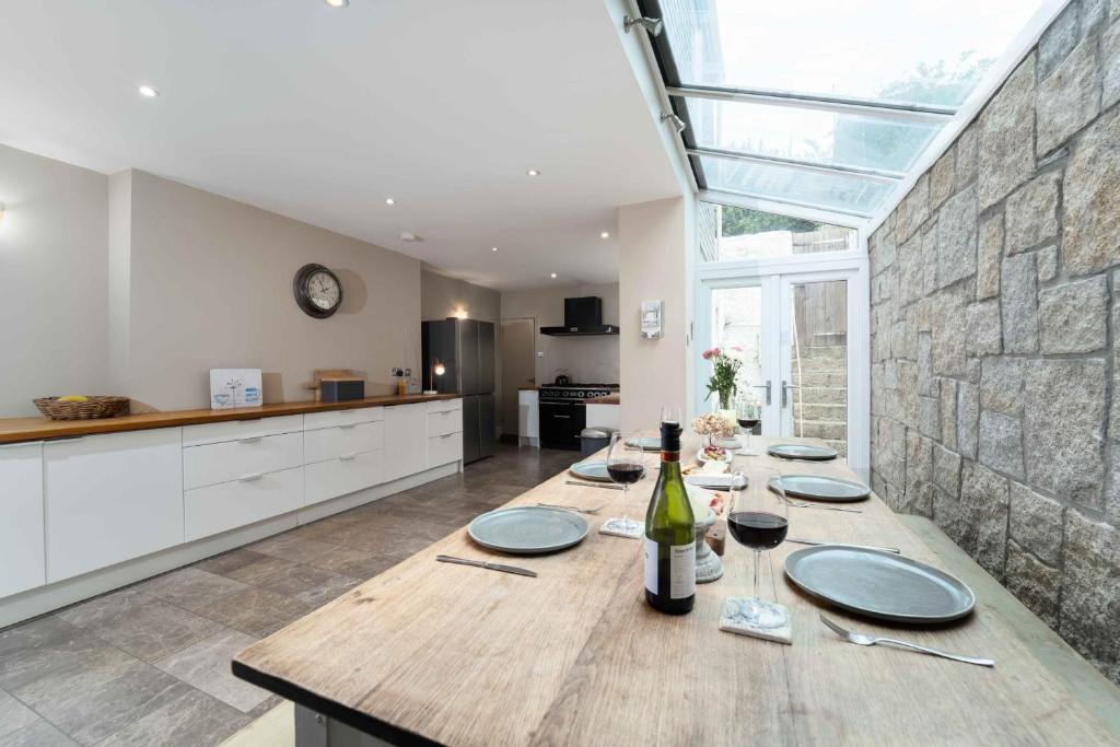 a kitchen with a table with a bottle of wine at Elysian in St Ives
