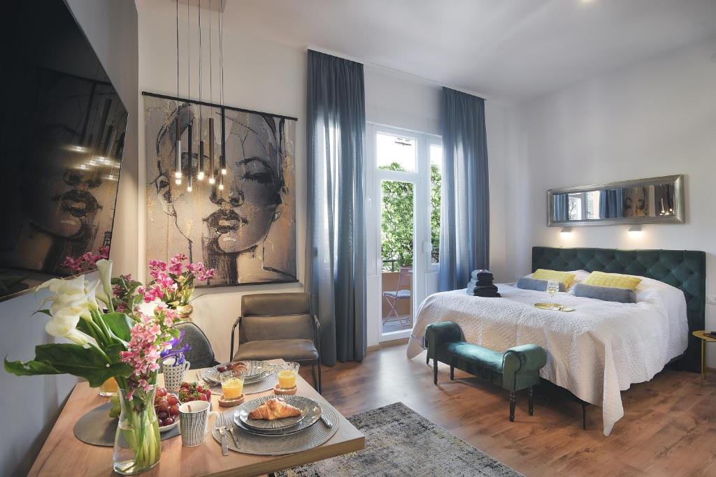 ein Wohnzimmer mit einem Bett und einem Tisch mit Blumen in der Unterkunft E&F Luxury Apartments in Pula