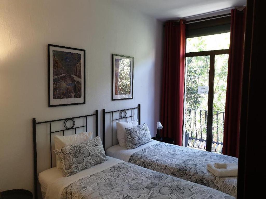 um quarto com 2 camas e uma janela em Hostal Absolut Stay em Barcelona