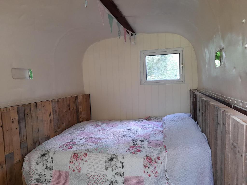 a bedroom with a bed in a room with a window at South View Shepard Hut 