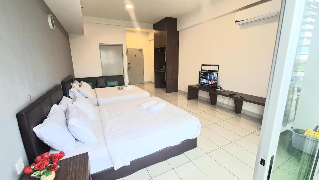 a hotel room with a bed and a television at Aeropod [5B]/Near Airport / 2 Queen Bed/ Netflix/Free Parking in Kota Kinabalu