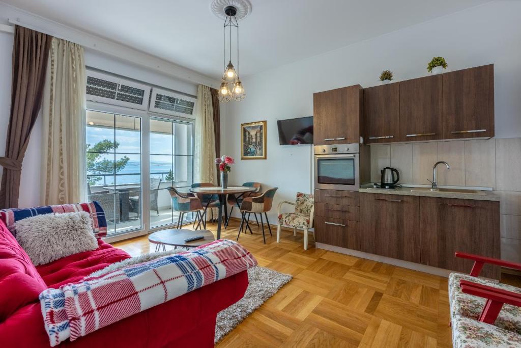 ein Wohnzimmer mit einem roten Sofa und einer Küche in der Unterkunft Villa Lucia in Crikvenica