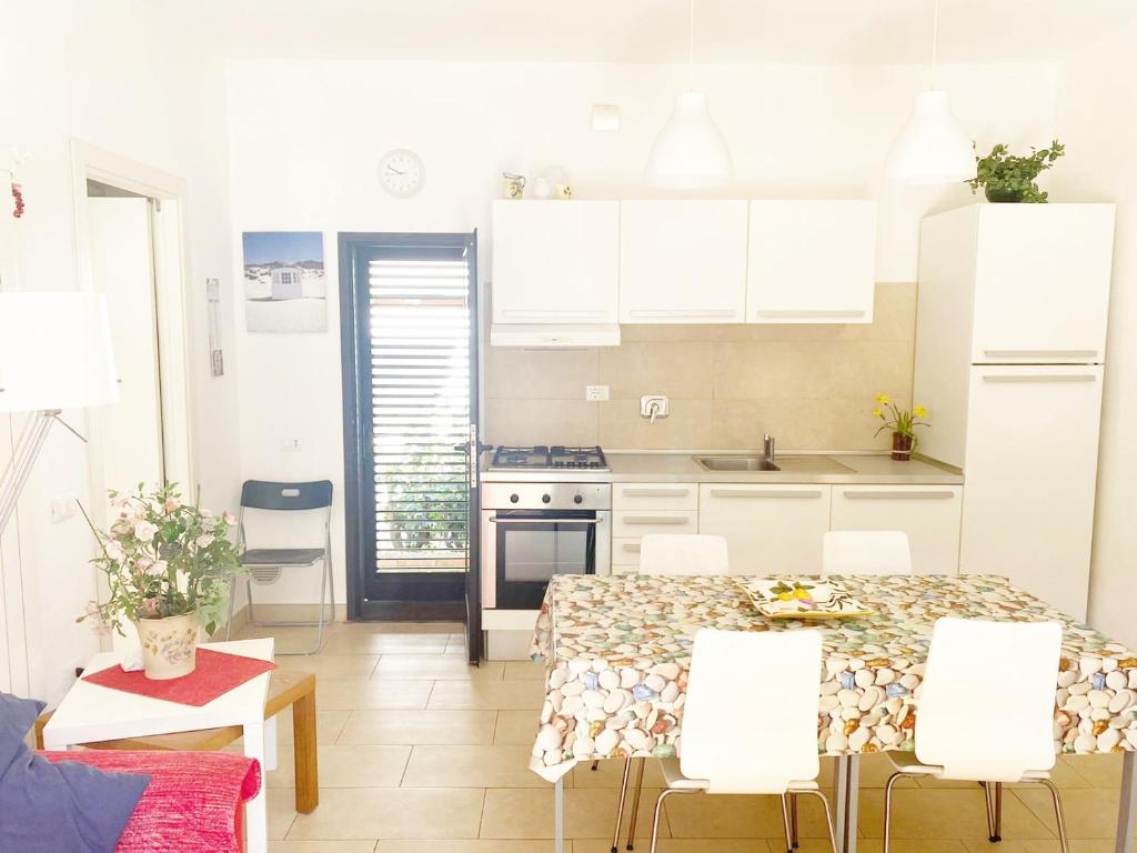 a kitchen with a table and chairs in a room at Casa Raffaella in Marina di Cecina