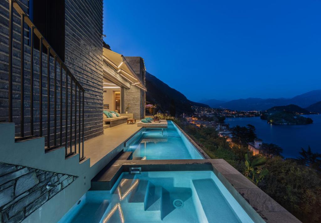 een zwembad aan de zijkant van een gebouw bij VILLA MOLLI Lago di Como in Sala Comacina