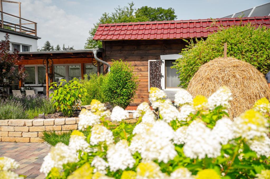 Ein Haus mit einem Haufen Blumen davor in der Unterkunft Spreewald Pension Tannenwinkel in Lübbenau