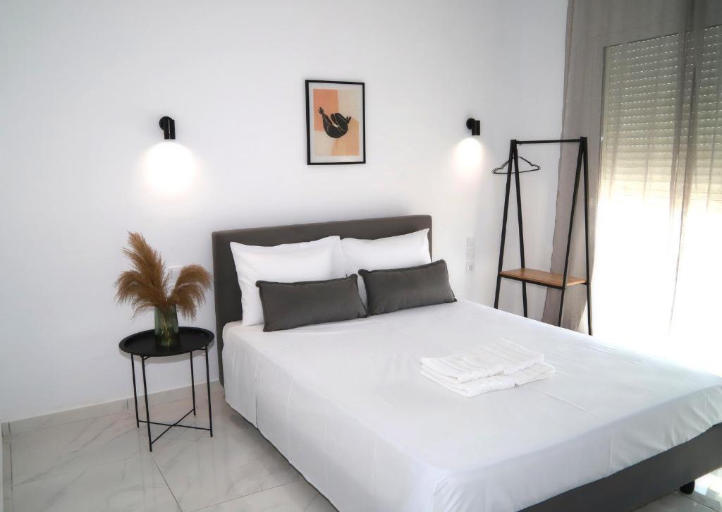 a bedroom with a white bed with a plant on it at Ktima Ayia Marina in Amalias