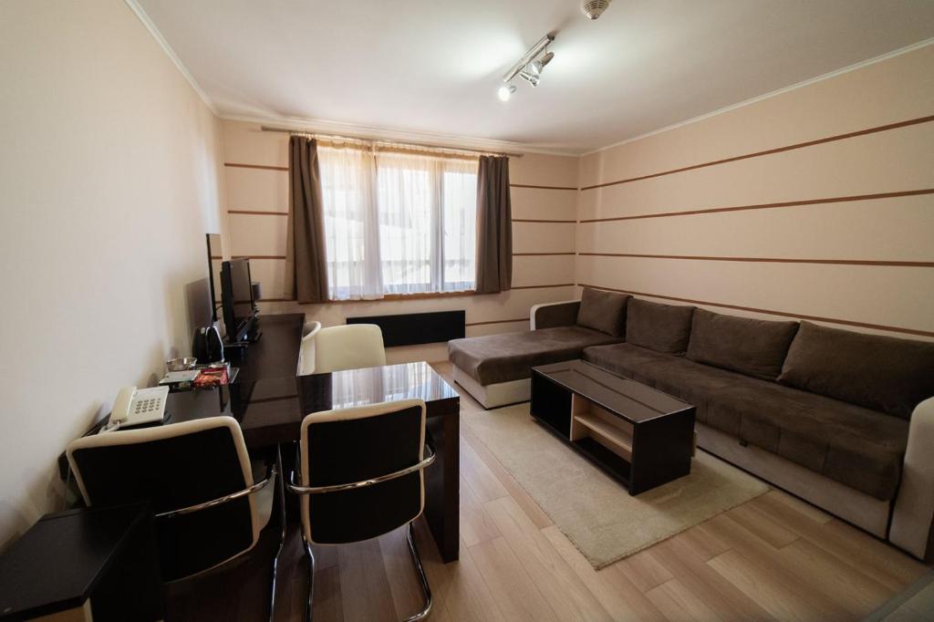 uma sala de estar com um sofá e uma mesa em Apartment Unna em Kopaonik