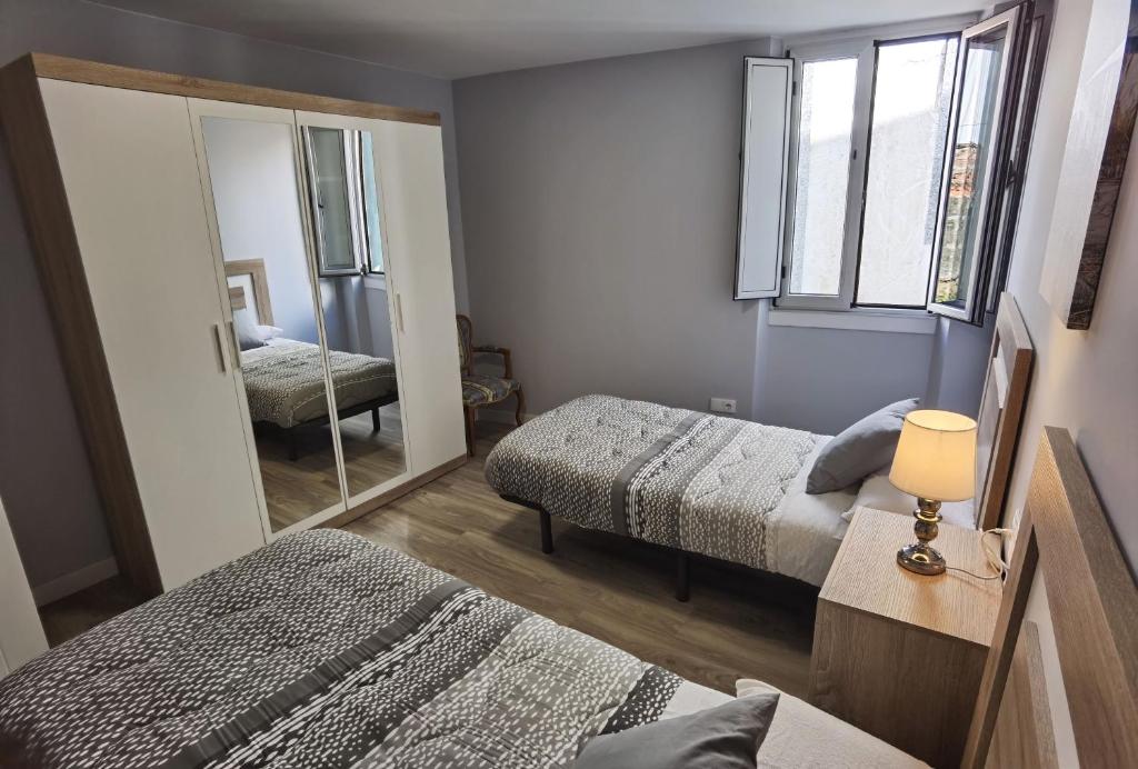 a bedroom with two beds and a mirror at Apartamentos Casa do Pan in Corme-Puerto