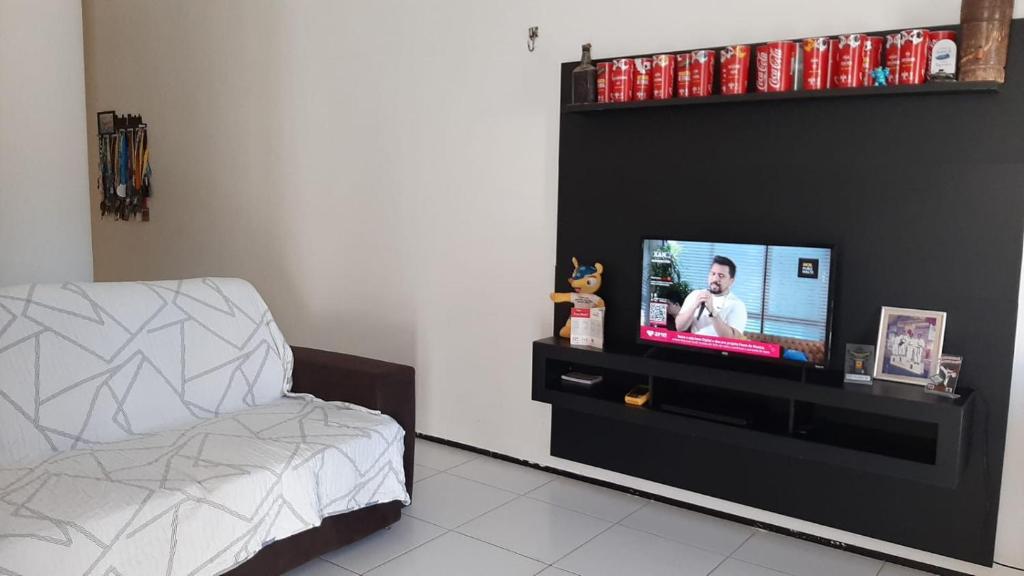 a bedroom with a bed and a television on a dresser at Cantinho arretado da Peste - Casa in Aquiraz