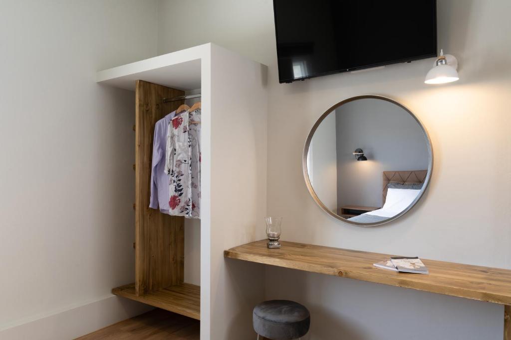 a bathroom with a mirror and a wooden shelf at Amarie House with Sea View & Sunset View in Oia