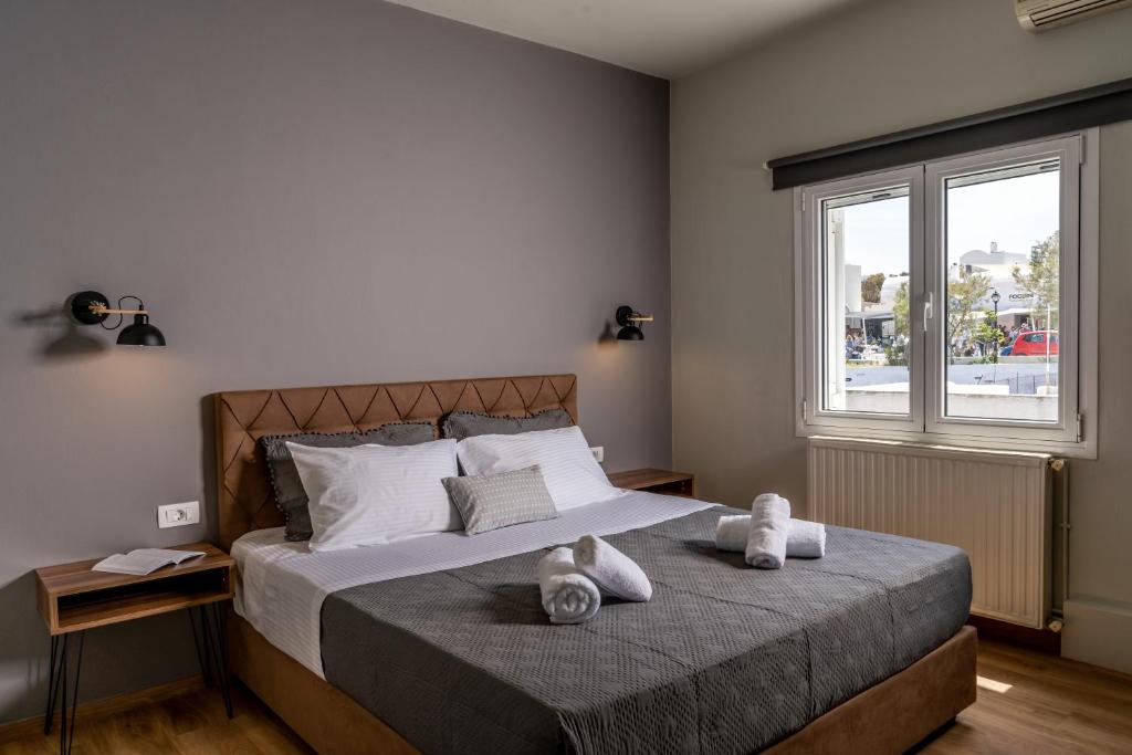 a bedroom with a bed with two stuffed animals on it at Amarie House with Sea View & Sunset View in Oia