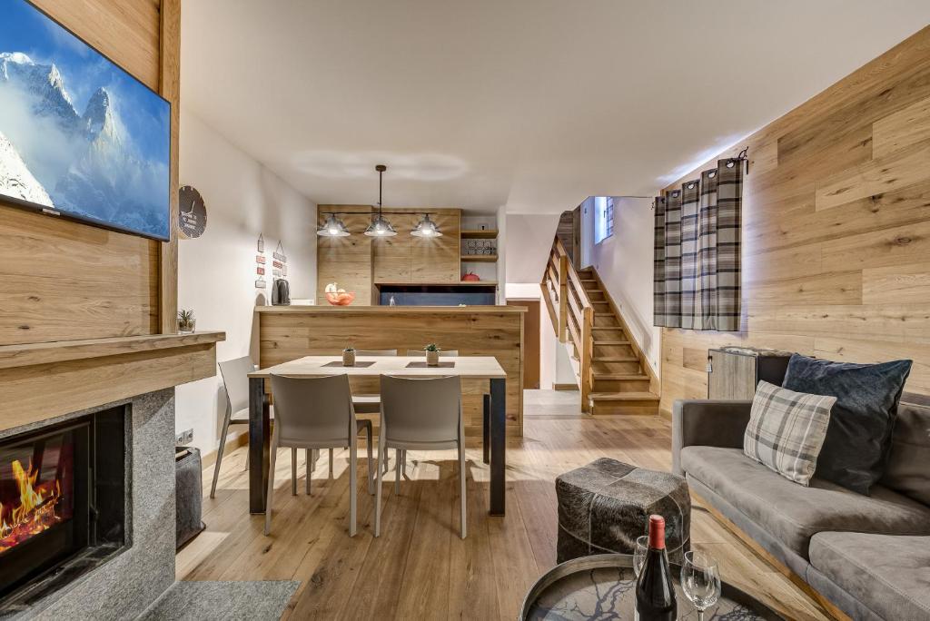 un salon avec une table et une cheminée dans l'établissement Pic Janvier - Alpes Travel - Les Praz (sleeps 4-6), à Chamonix-Mont-Blanc