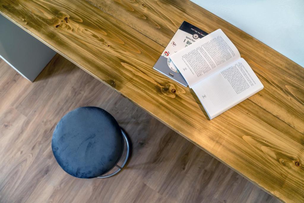 a wooden table with a book and a blue pillow at Amarie House with Sea View & Sunset View in Oia