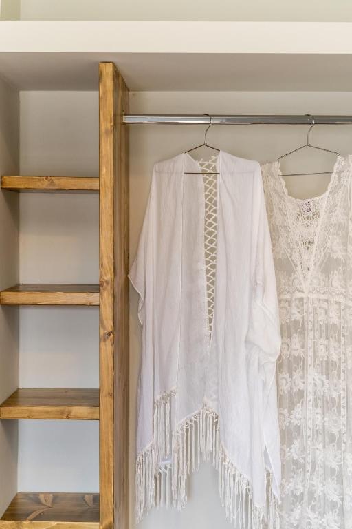 a white shirt and a dress on a shelf at Amarie House with Sea View & Sunset View in Oia