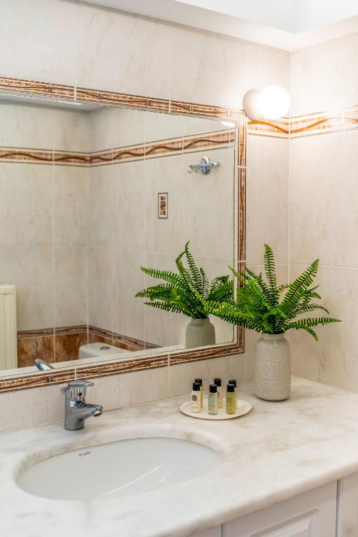 a bathroom with a sink and a mirror at Amarie House with Sea View & Sunset View in Oia