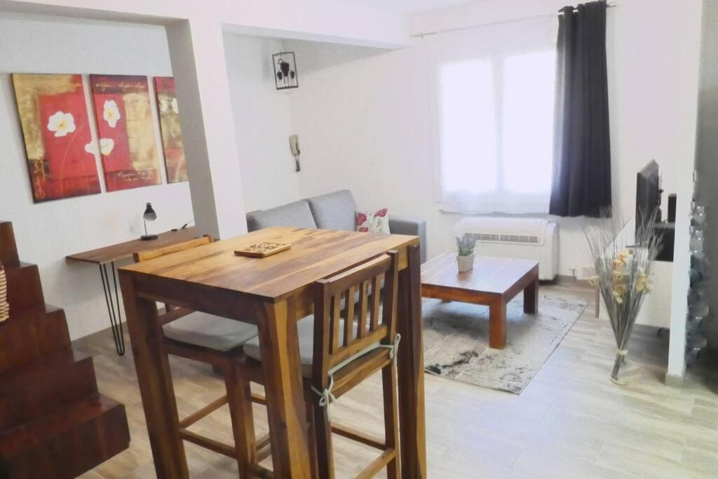 un salon avec une table et des chaises en bois dans l'établissement Tiloft, à Antibes