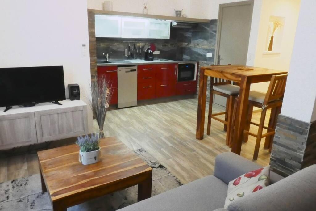 un soggiorno con tavolo e una cucina con armadi rossi di Tiloft a Antibes