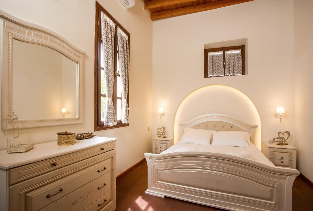 ein Schlafzimmer mit einem großen weißen Bett und einem Spiegel in der Unterkunft The Knight's House Old Town Rhodes in Rhodos (Stadt)