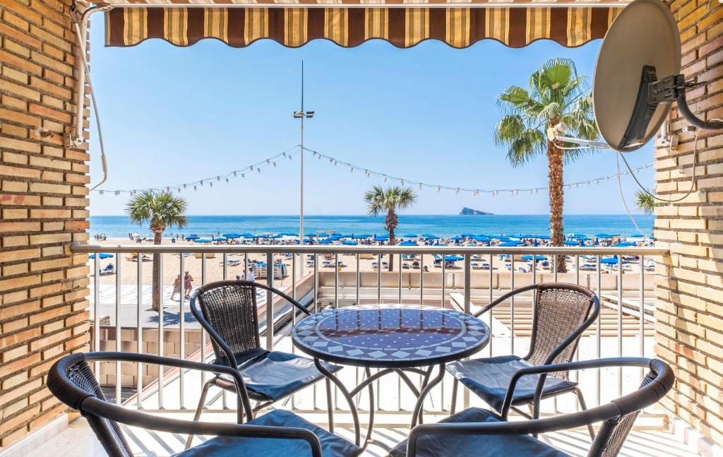 a patio with a table and chairs and the beach at Los Ranchos in Benidorm