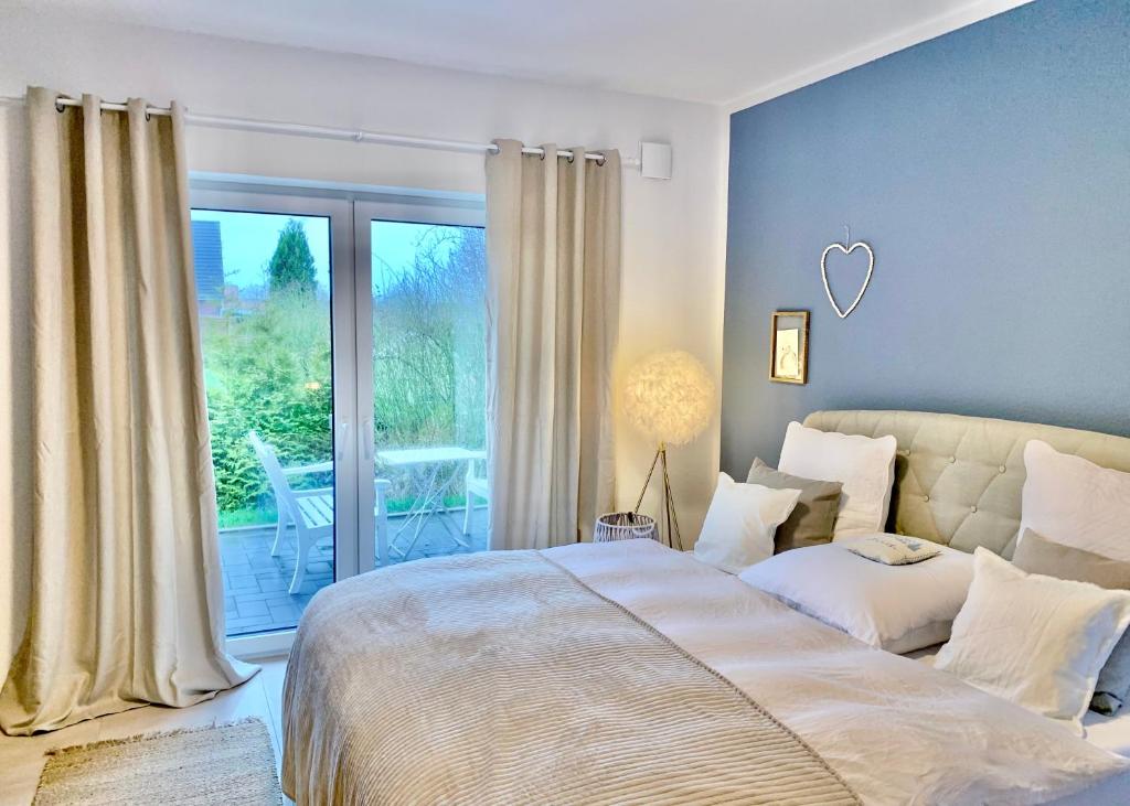 a bedroom with a bed and a large window at Freya Blue Ferienhaus in Weener