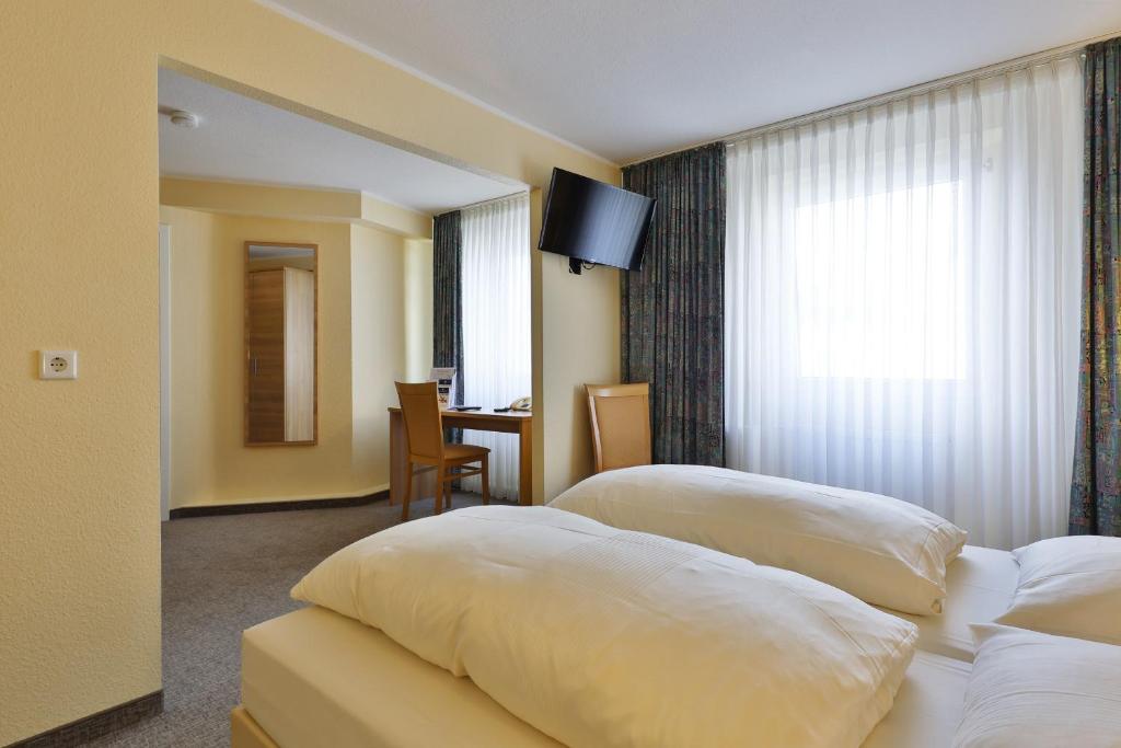 ヴッパータールにあるCity Partner Central-Hotel Wuppertalのベッド2台とテーブルが備わるホテルルームです。