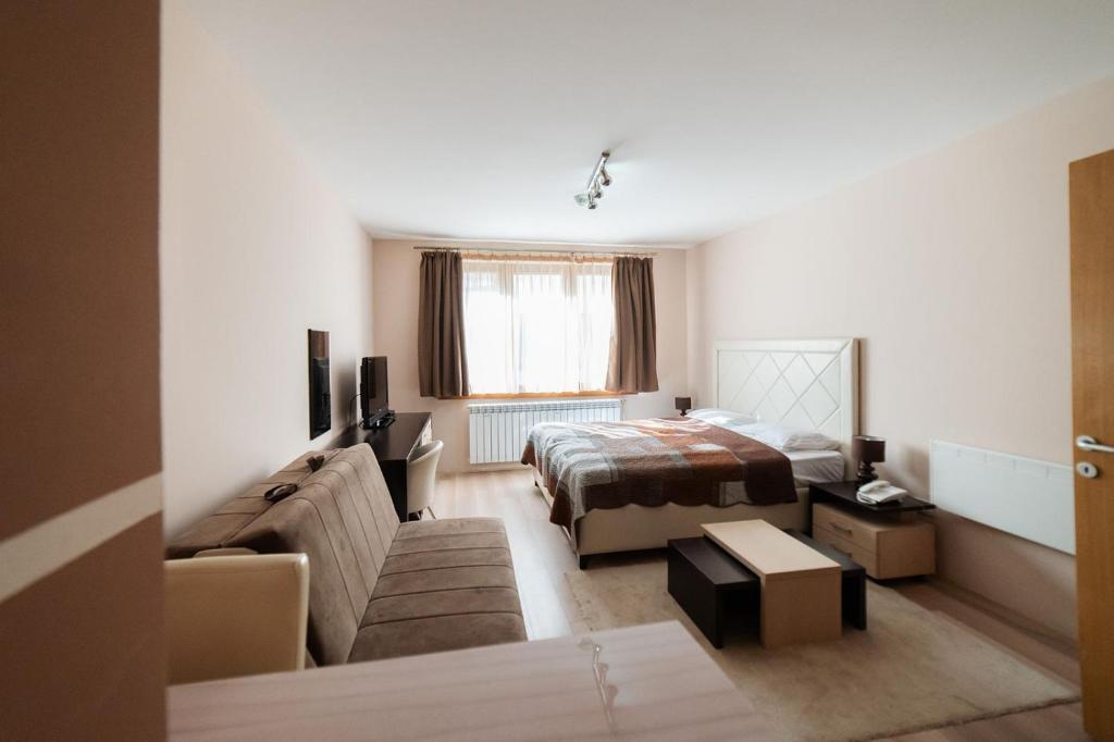 a hotel room with a bed and a couch at Studio Unna in Kopaonik