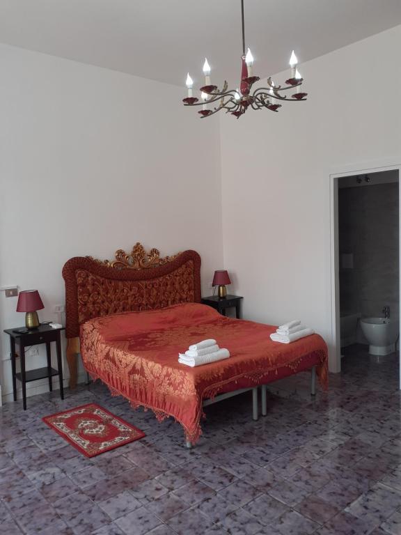 1 dormitorio con cama roja y lámpara de araña en Domus Morfeo, en Santa Maria Capua Vetere