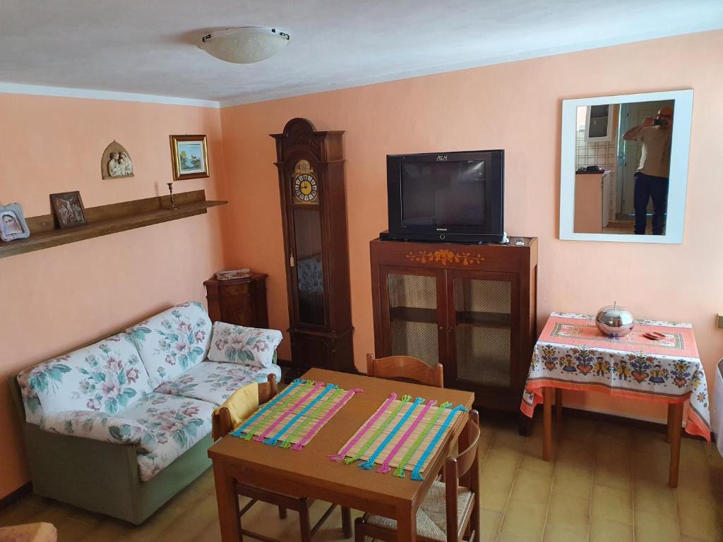 sala de estar con sofá y TV en La Casa di Agnese, en bedizzol