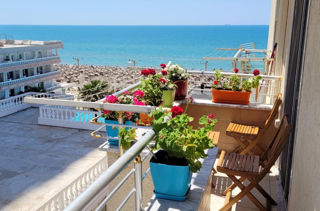 a balcony with flowers and a view of the beach at Beach View Apartment, Golem Durres in Durrës