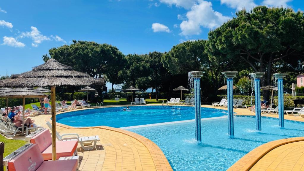 a large swimming pool with people sitting around it at Bicos 101 - Shared Pool - 4 Guests - Albufeira in Albufeira