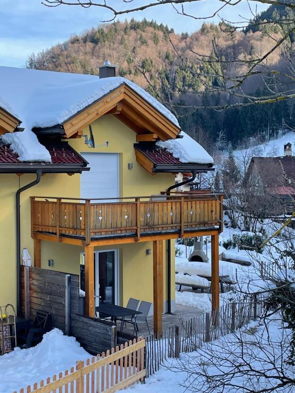 a house with a deck in the snow at Haus Seltschach in Arnoldstein