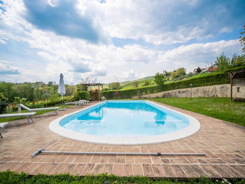 duży basen w podwórzu z dwoma ławkami w obiekcie Farmhouse in Città di Castello with Pool w mieście San Secondo