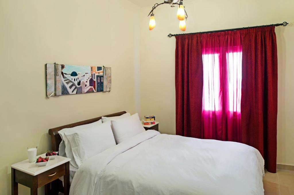 a bedroom with a bed and a red curtain at Galatia Villas in Fira
