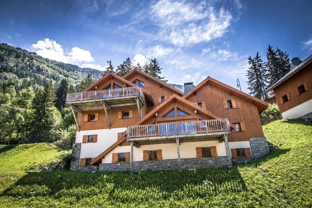 ein großes Holzhaus auf einem Hügel mit Bäumen in der Unterkunft Chalet Beyond - Gelinotte in 