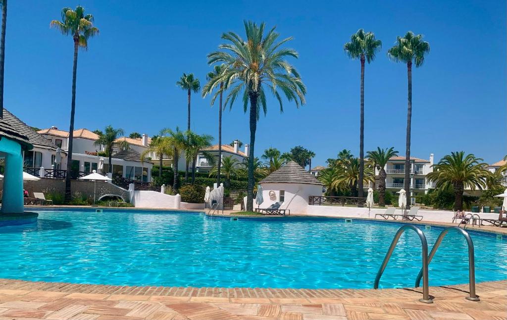 uma grande piscina com palmeiras ao fundo em Encosta do Lago - With Private Pool na Quinta do Lago