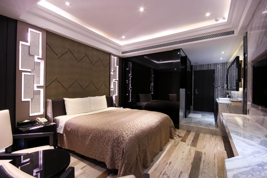 a bedroom with a large bed and a bathroom at Region Motel in Lukang